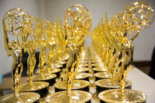 A close up view of golden Emmy Awards trophies lined up on a table, HD Desktop Wallpaper
