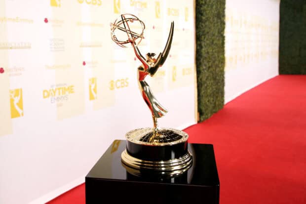 The golden Emmy Awards trophy stands on a black pedestal on a red carpet at the event, HD Desktop Wallpaper