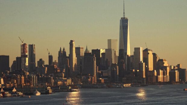The New York skyline features iconic buildings at sunset over the water, 4K Desktop Wallpaper