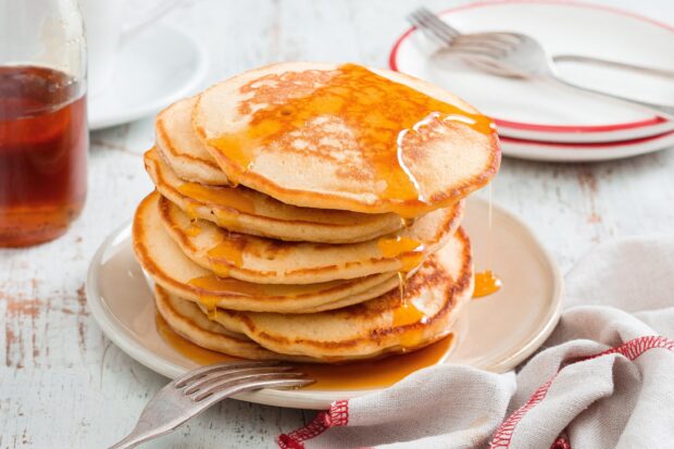 A stack of golden pancakes with syrup dripping on a plate, 2K Desktop Wallpaper