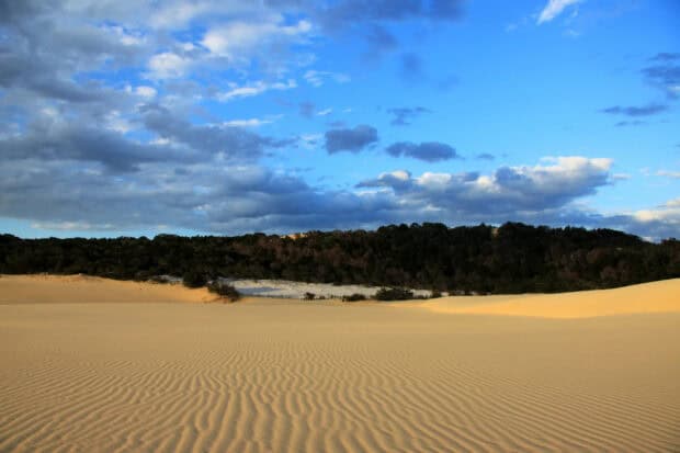 The golden sand dunes contrast with the cloudy blue sky on Fraser Island, 2K Desktop Wallpaper