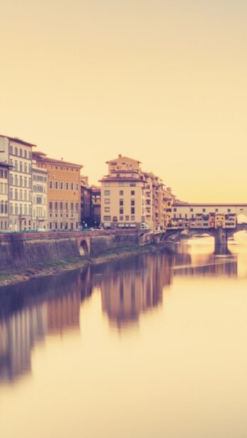 The Ponte Vecchio shows colorful buildings reflected in the calm river at sunset, HD Phone Wallpaper