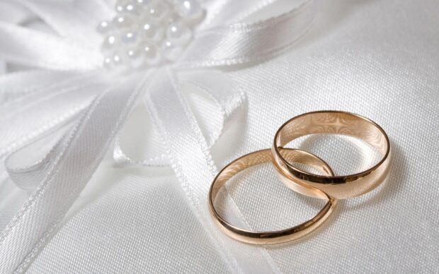 Two golden wedding rings resting on white satin fabric with a decorative bow, HD Desktop Wallpaper