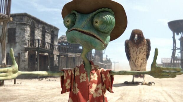 A chameleon character stands with arms outstretched in a desert town scene, HD Desktop Wallpaper