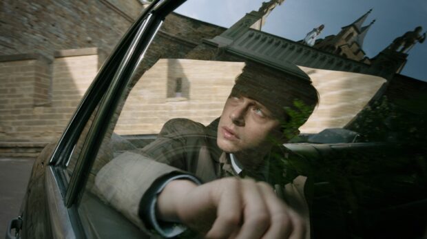A man is seen through a car window in a reflective shot with architecture behind, HD Desktop Wallpaper