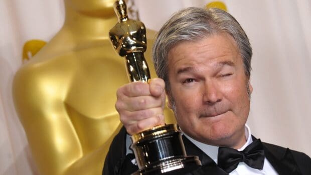 Gore Verbinski proudly holds an Oscar award while winking in a tuxedo, HD Desktop Wallpaper