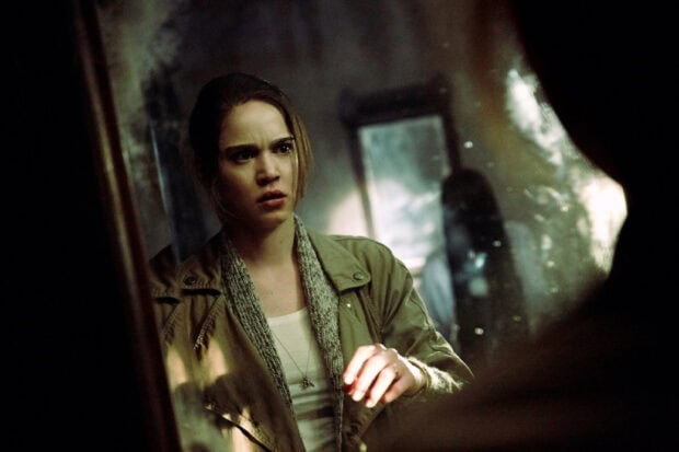 A woman looks shocked and frightened while staring in a mirror in a dark room, HD Desktop Wallpaper