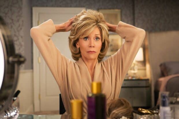 A woman from Grace And Frankie Netflix wallpapers is fixing her hair while looking in a mirror, HD Desktop Wallpaper