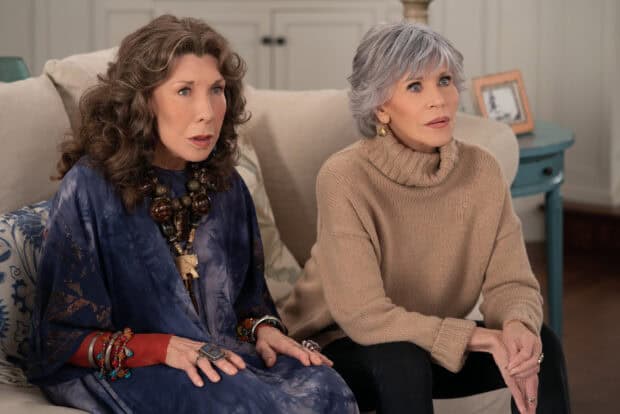 Grace And Frankie Netflix Wallpapers show two women sitting closely on a sofa in a living room, HD Desktop Wallpaper
