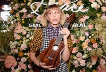 Grace Vanderwaal holding a wooden ukulele in front of a floral background, HD Desktop Wallpaper