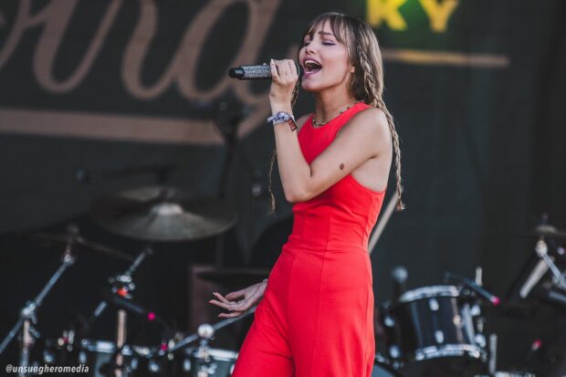 Grace Vanderwaal sings passionately during a live performance in a red outfit, HD Desktop Wallpaper