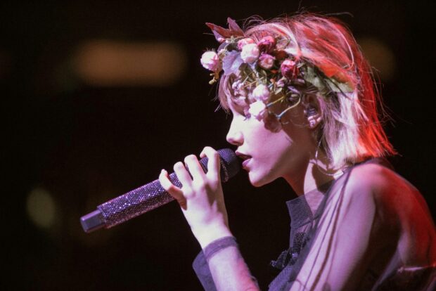 Grace Vanderwaal sings passionately with a floral headpiece and a sparkling microphone, HD Desktop Wallpaper