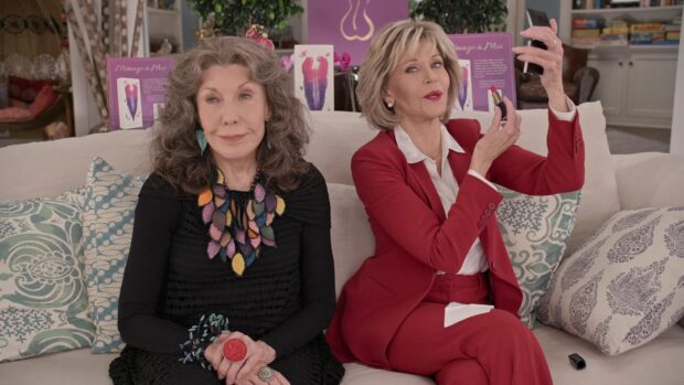 Grace and Frankie characters sitting on a couch with colorful cushions and one taking a selfie, HD Desktop Wallpaper