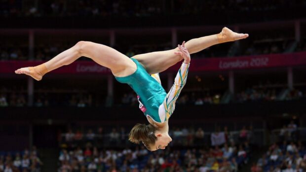 A gymnast performs a balanced flip in an acrobatic gymnastics routine, HD Desktop Wallpaper