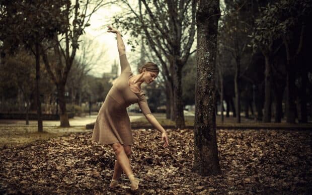 A ballet dancer performs gracefully in the autumn forest surrounded by dry leaves, HD Desktop Wallpaper