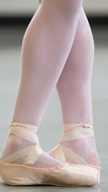 A close up of ballet dancer's feet wearing classic pointe shoes in a graceful pose, HD Mobile Wallpaper