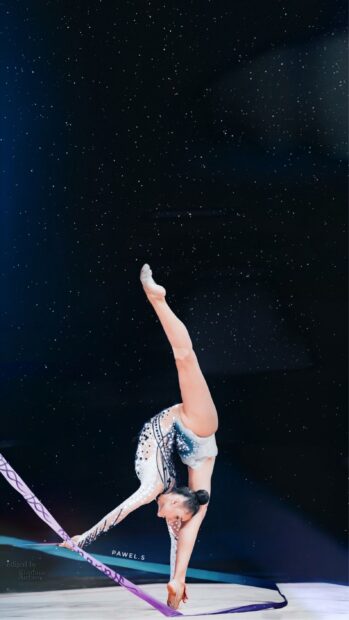 A rhythmic gymnast performs a flexible pose with a ribbon in hand, 2K Phone Wallpaper