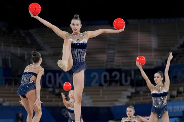 A group of gymnasts performing a routine with red balls during a competition, HD Desktop Wallpaper