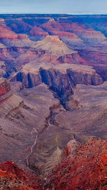 The Grand Canyon displays layered red and purple rock formations under a clear sky, HD Phone Wallpaper