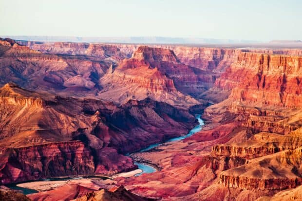 The Grand Canyon shows deep layered red rock formations with a winding river, HD Desktop Wallpaper