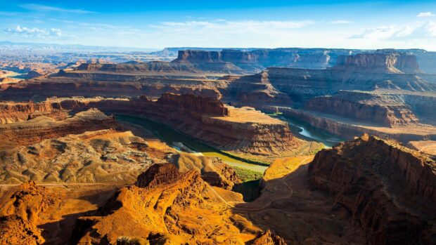 The Grand Canyon displays layered red rock formations under a bright blue sky, 4K Desktop Wallpaper