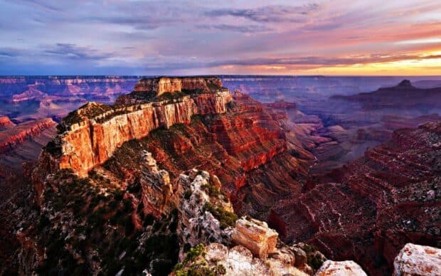 A vivid sunset reveals layers of the Grand Canyon landscape with colorful cliffs and shadows, HD Desktop Wallpaper