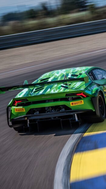 A green Lamborghini is driving fast on a race track with blurred surroundings showing speed and motion, 4K Phone Wallpaper