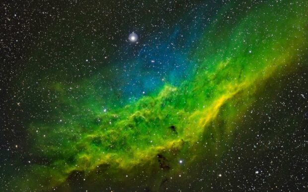 A vibrant green nebula with stars scattered throughout the dark space, 2K Desktop Wallpaper