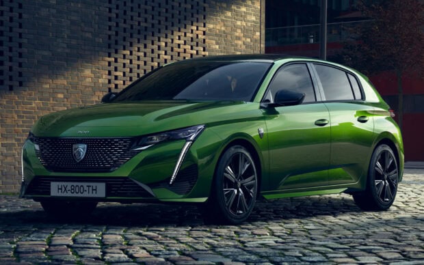 A green Peugeot 308 is parked on a cobblestone street with a brick wall background, HD Desktop Wallpaper
