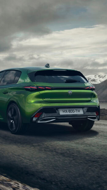 The green Peugeot 308 is parked on a mountain road under a cloudy sky, 4K Phone Wallpaper