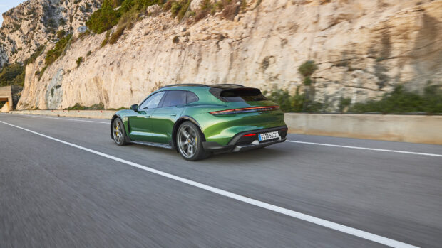 A green Porsche Taycan is driving fast on a mountain road with rocky cliffs in the background, 4K Desktop Wallpaper