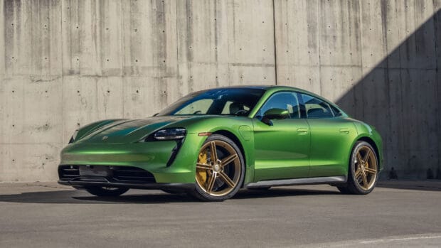 A green Porsche Taycan is parked in front of a concrete wall in sunlight, 4K Desktop Wallpaper