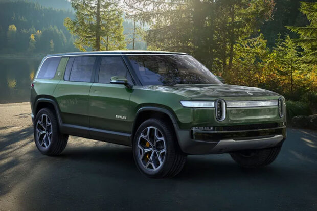 A green Rivian electric vehicle is parked near a lake surrounded by trees, HD Desktop Wallpaper