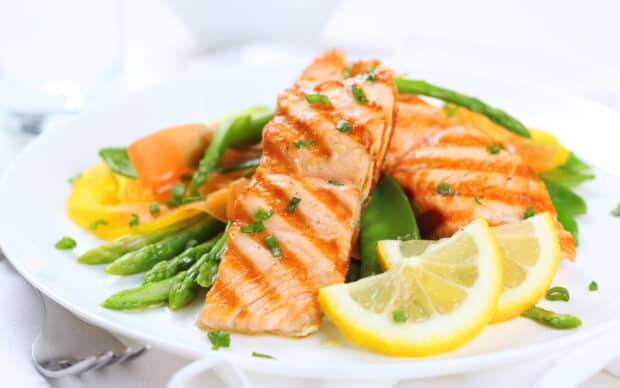 A plate of grilled salmon served with fresh asparagus, carrots, and lemon slices, 2K Desktop Wallpaper