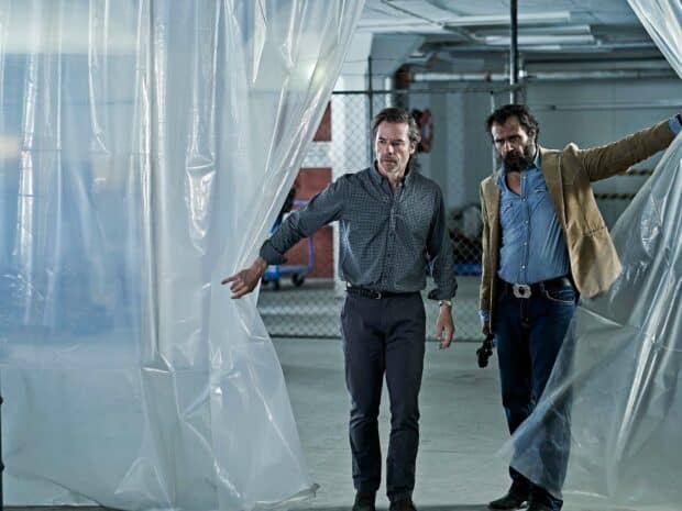 Guy Pearce and a man enter through plastic curtains in a dimly lit warehouse, HD Desktop Wallpaper