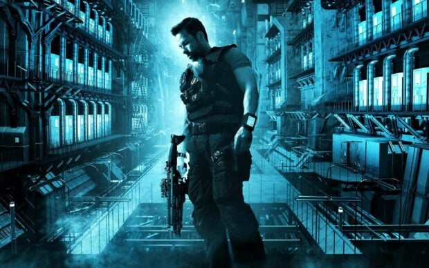 Guy Pearce is standing in a large industrial facility holding a futuristic rifle, HD Desktop Wallpaper