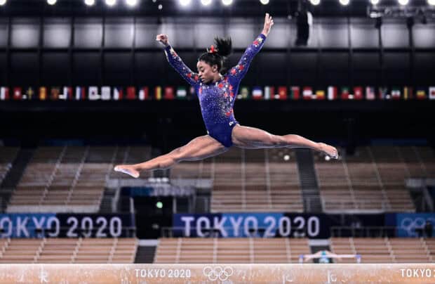 A gymnast performs a split leap on the balance beam during a competition at Tokyo 2020, HD Desktop Wallpaper