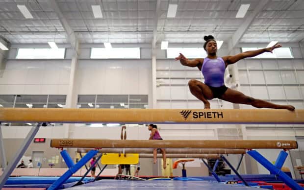 A gymnast is balancing on a beam in a training gym, HD Desktop Wallpaper