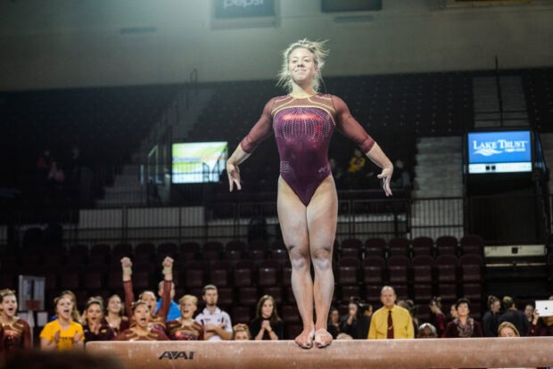 A gymnast performing on a balance beam during a competition, 2K Desktop Wallpaper