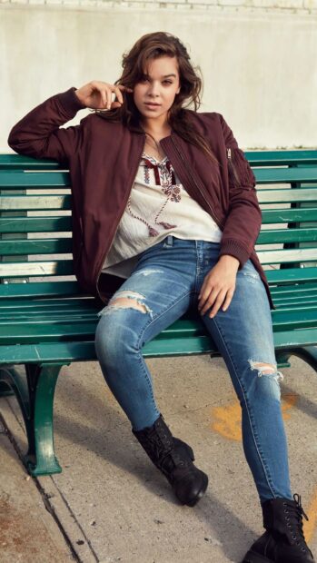 Hailee Steinfeld Wallpapers shows a relaxed pose wearing a maroon jacket and ripped jeans, HD Phone Wallpaper