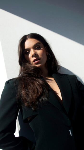 Hailee Steinfeld is posing in a black outfit against a light wall, HD Phone Wallpaper