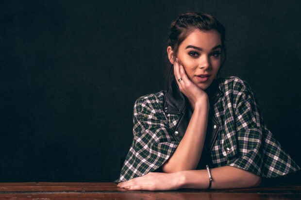 Hailee Steinfeld poses with her hand on her face wearing a plaid jacket in a studio setting, 2K Desktop Wallpaper