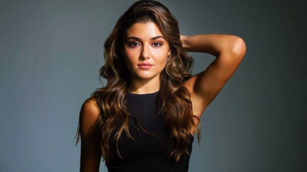 Hande Ercel is posing with one arm behind her head in a black sleeveless top, HD Desktop Wallpaper