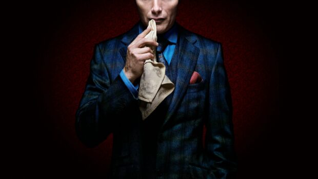 A man in a dark plaid suit holds a cloth near his face in a dimly lit room, 2K Desktop Wallpaper