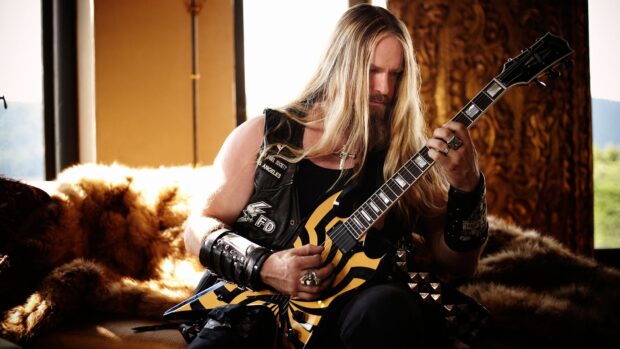 A long haired guitarist focused on playing a yellow and black electric guitar indoors, HD Desktop Wallpaper