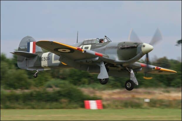 A Hawker Hurricane aircraft is flying low over a grassy field near trees, HD Desktop Wallpaper