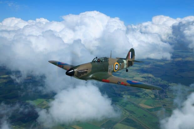A Hawker Hurricane aircraft is flying above the clouds over farmland, HD Desktop Wallpaper