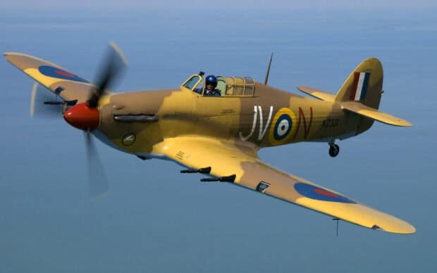 A Hawker Hurricane fighter plane flies over the ocean with its propeller spinning, HD Desktop Wallpaper