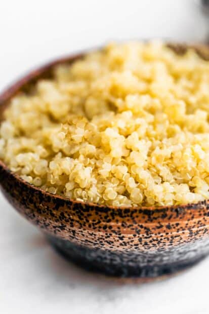 A close up of healthy cooked quinoa filling a speckled ceramic bowl, HD Mobile Wallpaper
