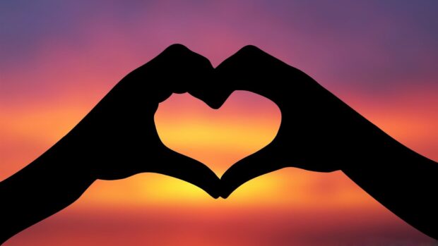 Two hands create a heart shape against a colorful sunset sky, 4K Desktop Wallpaper